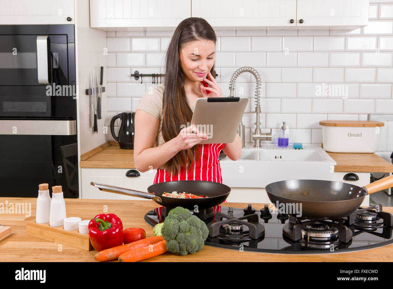 Kaukasische attraktive Frau mit Tablet-PC in der Küche. Stockfoto