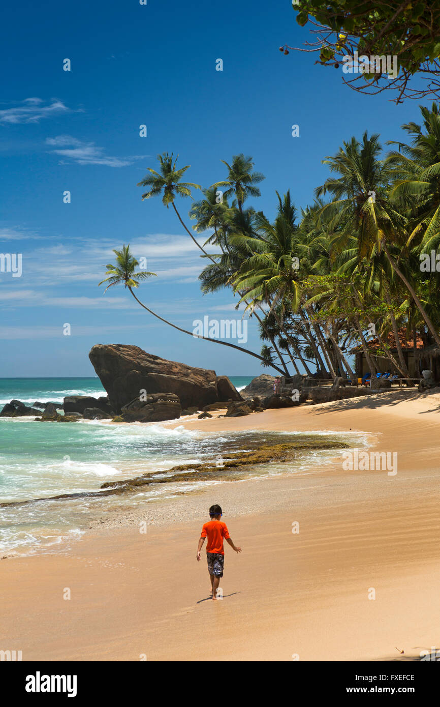 Sri Lanka Unawatuna, Thalpe, Wijaya, Kind zu Fuß am idyllischen tropischen Strand Stockfoto