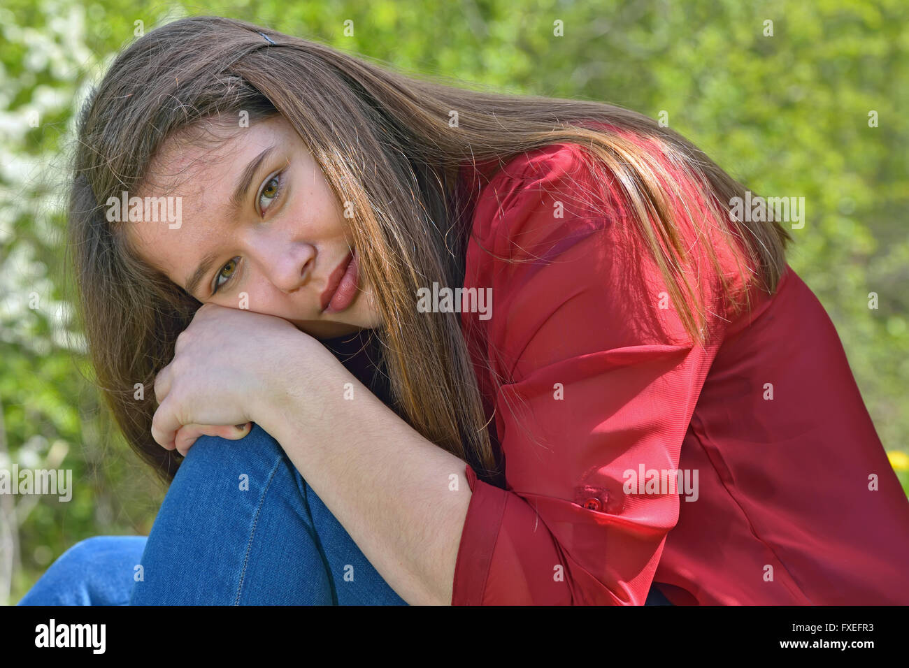 Teen Mädchen sitzt umarmt die Knien im freien Stockfoto