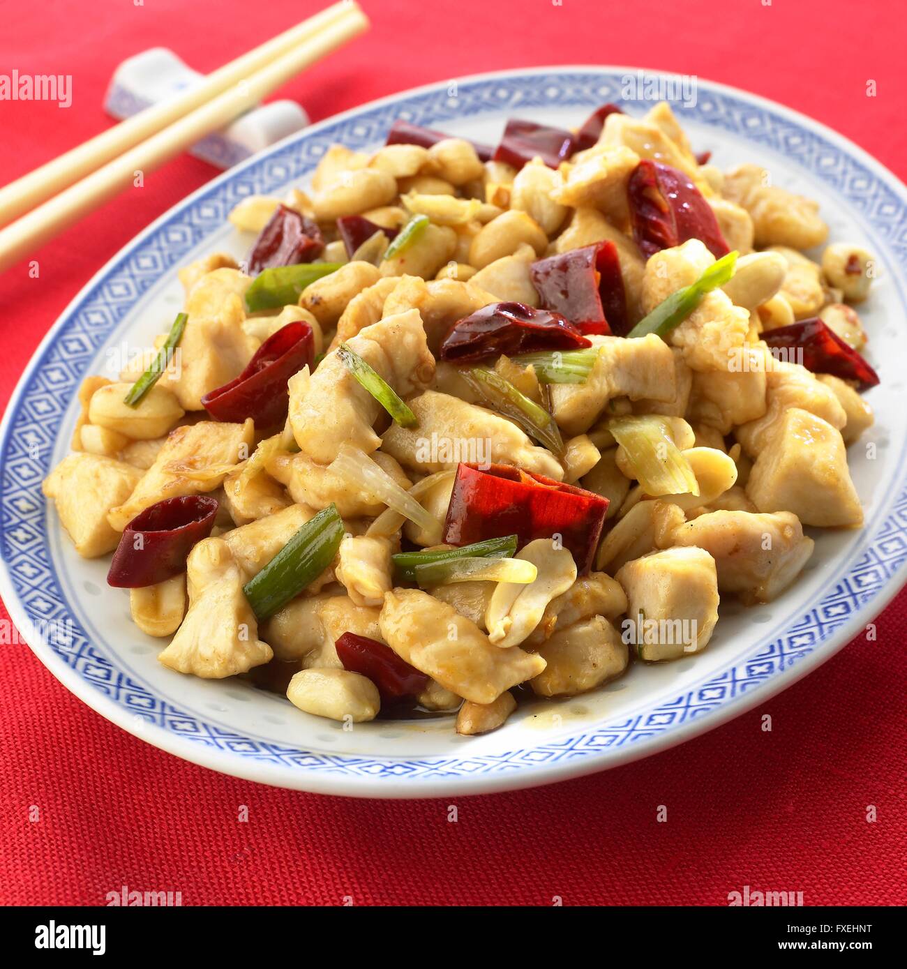 Kung Pao Chicken, ein traditionelles Gericht der Szechuan gewürfelte Hühnerbrust mit Chili und Cashewnüssen, serviert auf einer Platte anrichten, mit Stäbchen Stockfoto