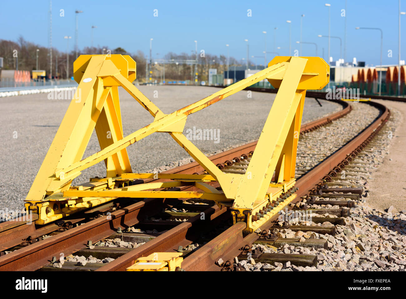 Leuchtend gelber Zug Prellbock oder Stoßfänger am Ende einer Eisenbahnstrecke. Stockfoto