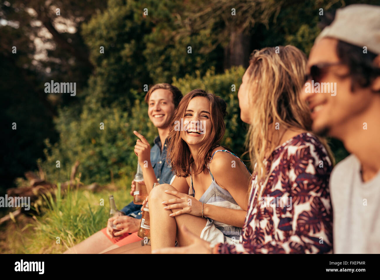 Porträt von fröhlichen jungen Freunden hängen mit Bier. Gruppe von Freunden im Freien zu sitzen und Spaß haben. Stockfoto