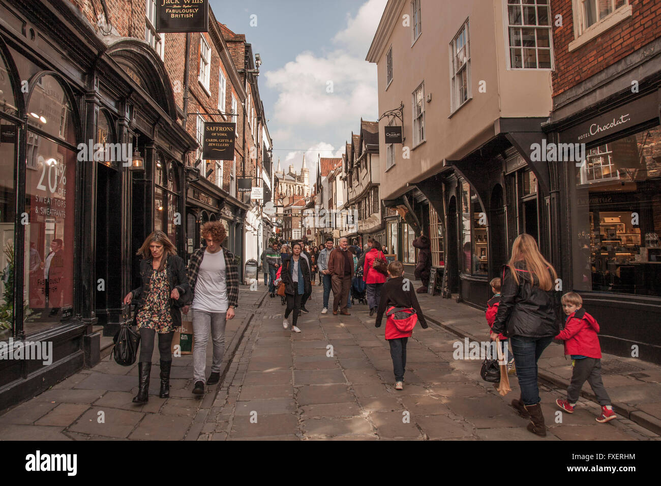 Ein Blick auf die belebte Stonegate-Straße in der historischen Stadt York, North Yorkshire, England, UK mit York Minster im Hintergrund Stockfoto