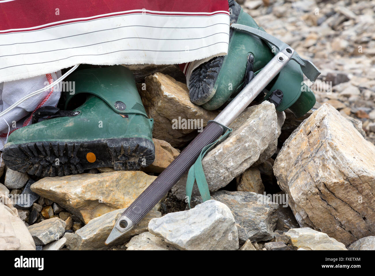 Alte Kunststoff Bergschuhe und Eispickel auf Stein Stockfoto