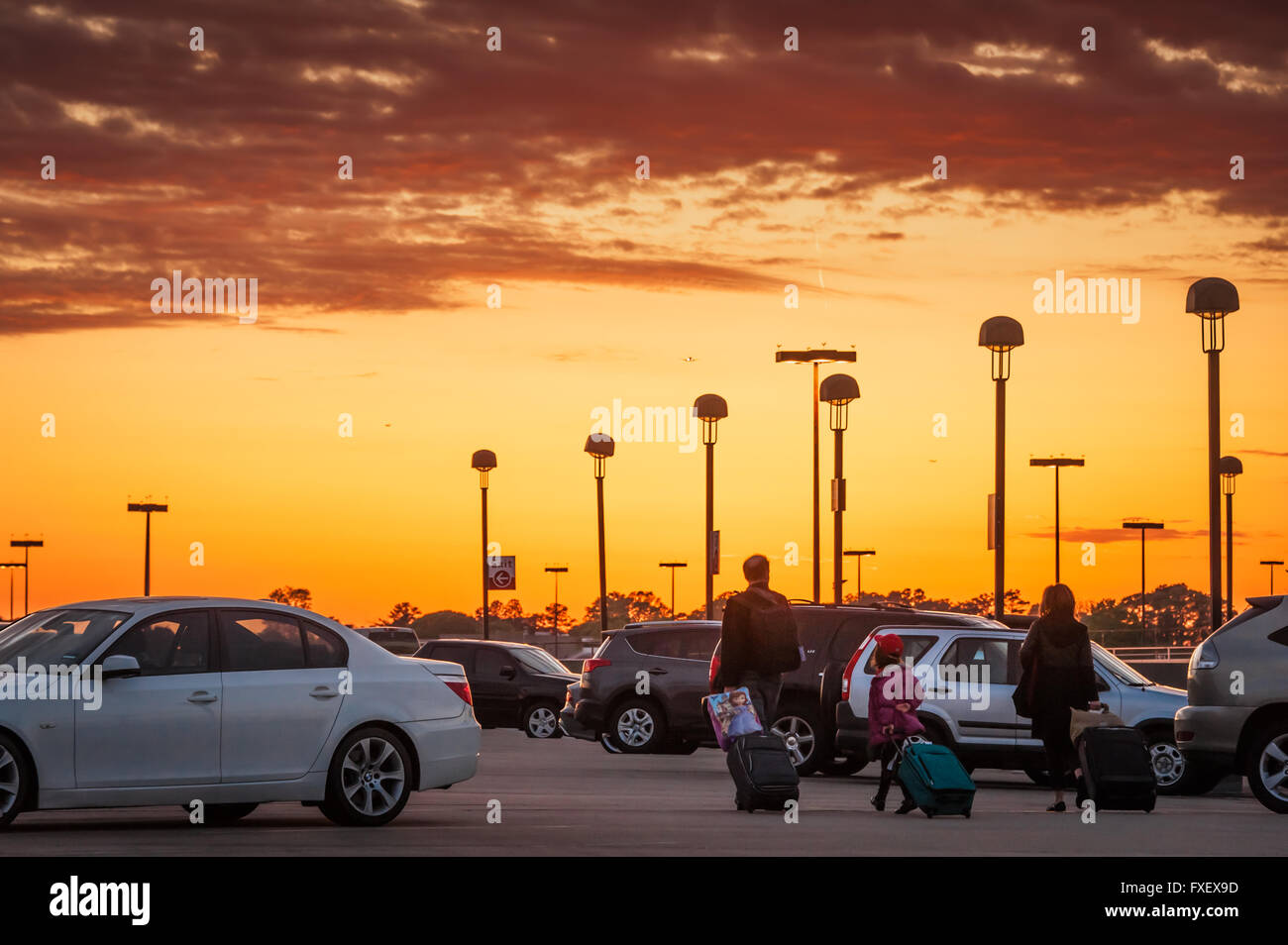 Familie ziehen Gepäck zu ihrem Auto auf der oberen Ebene Parkdeck am Atlanta International Airport in Atlanta, Georgia, USA. Stockfoto