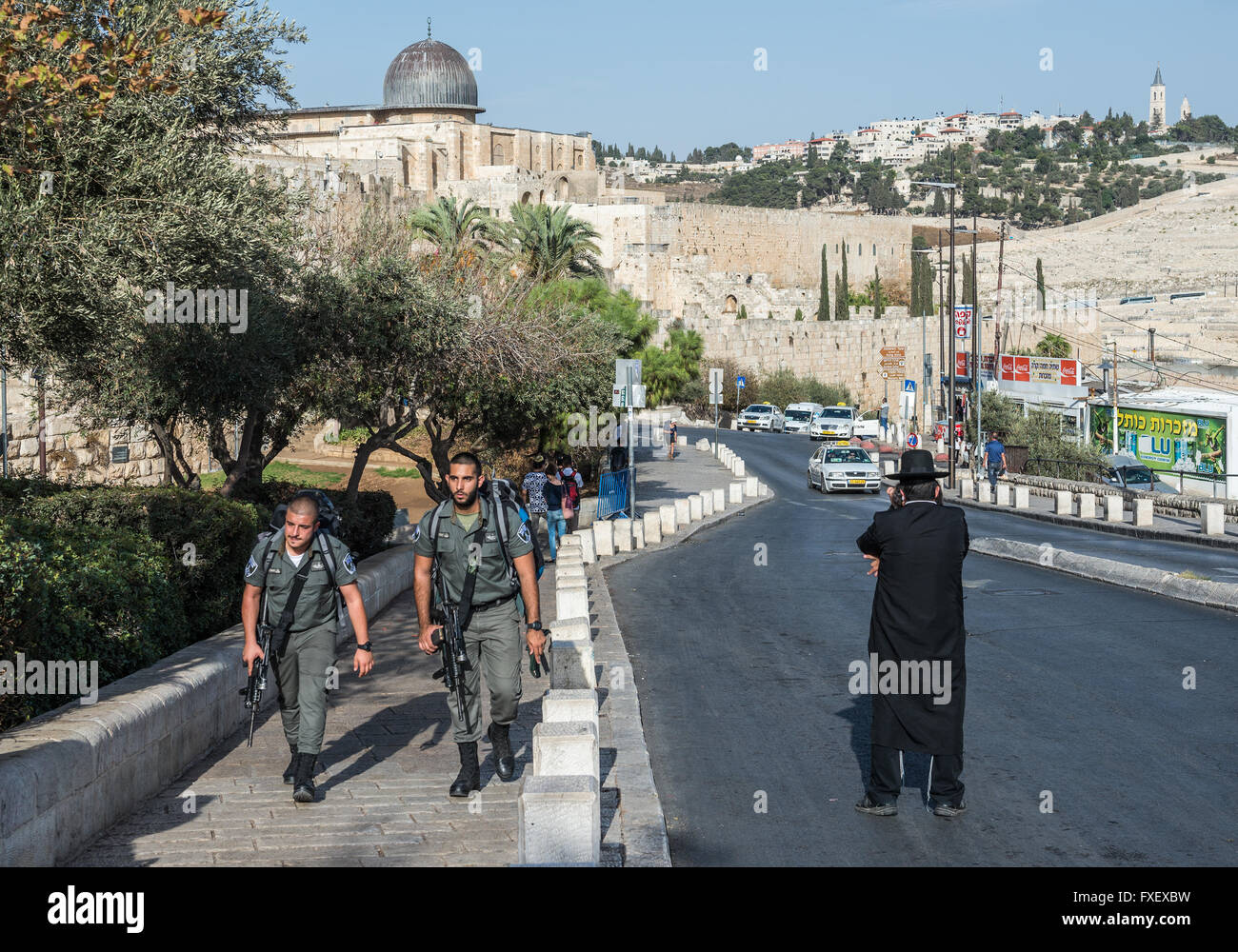 Orthodoxer Jude und israelische Grenzpolizei patrouillieren auf Ma'ale HaShalom Straße in Jerusalem, Israel. Al-Aqsa-Moschee im Hintergrund Stockfoto