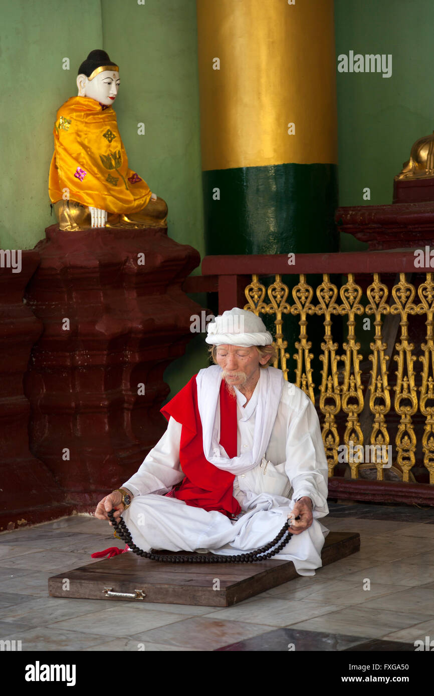 Ein Schneidersitz Anbeter beten im Nebengebäude der Paya Shwedagon, in Yangon (Myanmar) Croyant Priant Dans le Tempel Shwedagon Stockfoto