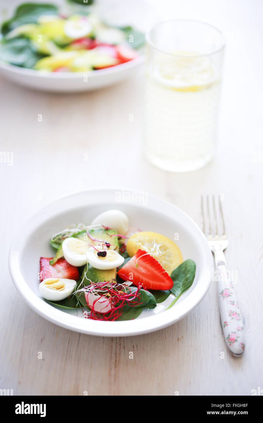 Baby-Spinat, Avocado, Zitrone, Erdbeeren und Wachtel-Eiern-Salat Stockfoto
