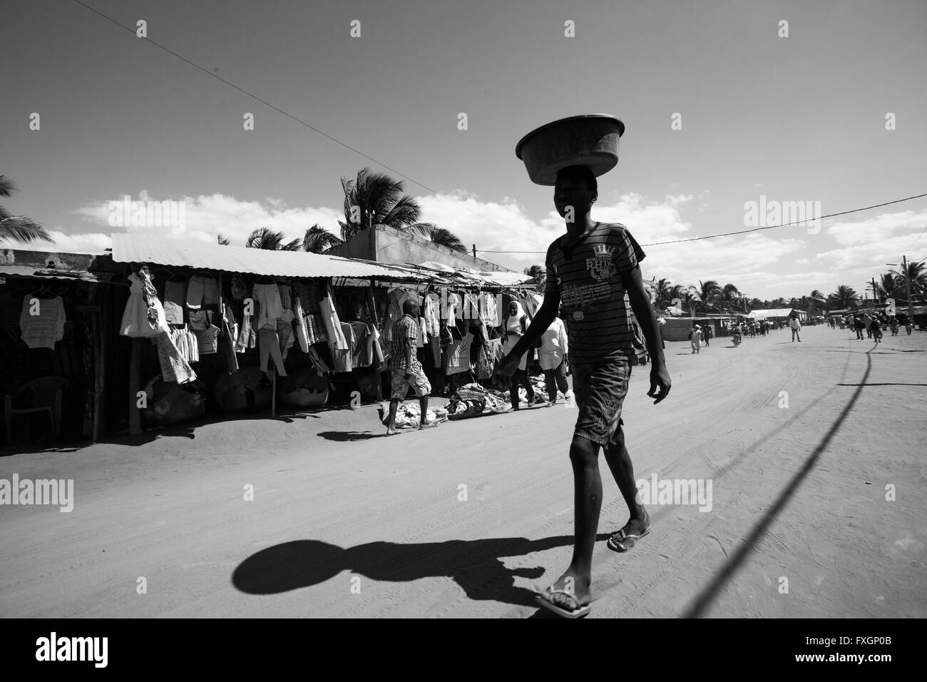 Mosambik, Frauen zu Fuß auf der Straße in typischer Tracht mit Eimer auf dem Kopf, schwarz und weiß, B&W. Stockfoto