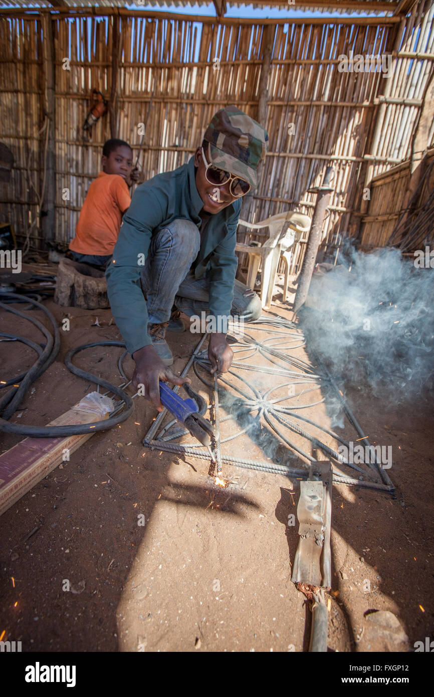 Mosambik, ein Mann und ein Kind in einer Schlosserei Lackierbetrieb Schweißen Stockfoto