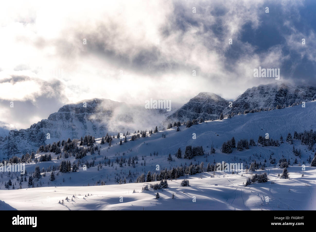 Wolken über schneebedeckte Berge Stockfoto