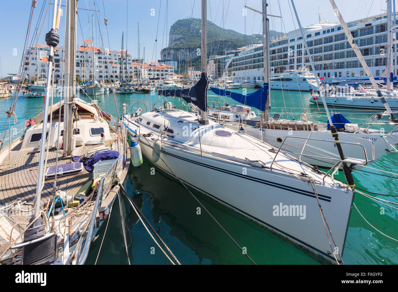 Gibraltar.  Yachten ankern in der Marina Bucht, neben Ocean Village.  Der Felsen von Gibraltar im Hintergrund. Stockfoto