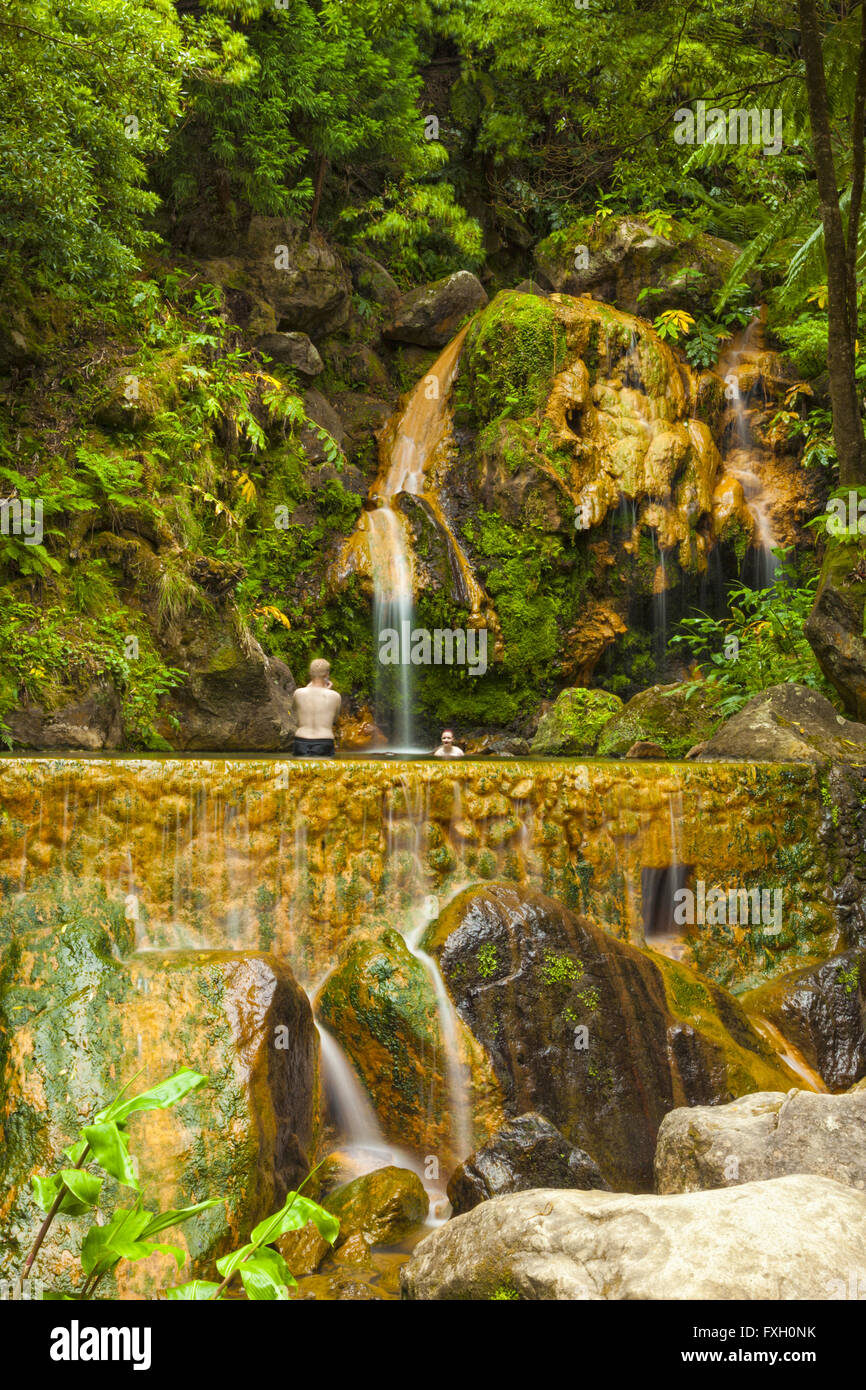 Touristen, Baden am Caldeira Velha (alte Kessel), einen Pool, gespeist von einem heißen Wasserfall auf der Insel Sao Miguel, Azoren Stockfoto