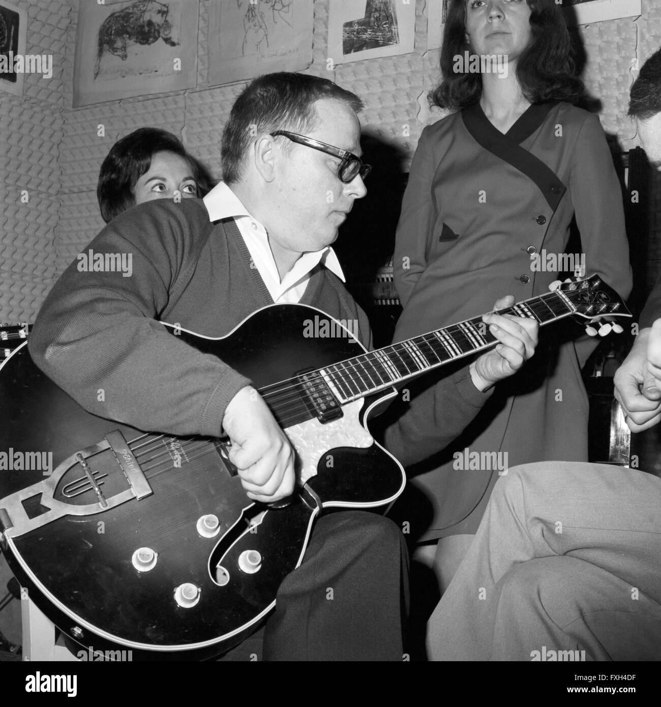 Der Deutsche Jazzgitarrist Und Publizist Werner Pöhlert (Anzug Und Brille) in Seiner Gitarrenschule, 1960er Jahre Deutschland. Deutscher jazz Autor und Gitarre Spieler Werner Poehlert an seiner Gitarrenschule, Deutschland der 1960er Jahre.  6x6swNeg25 Stockfoto