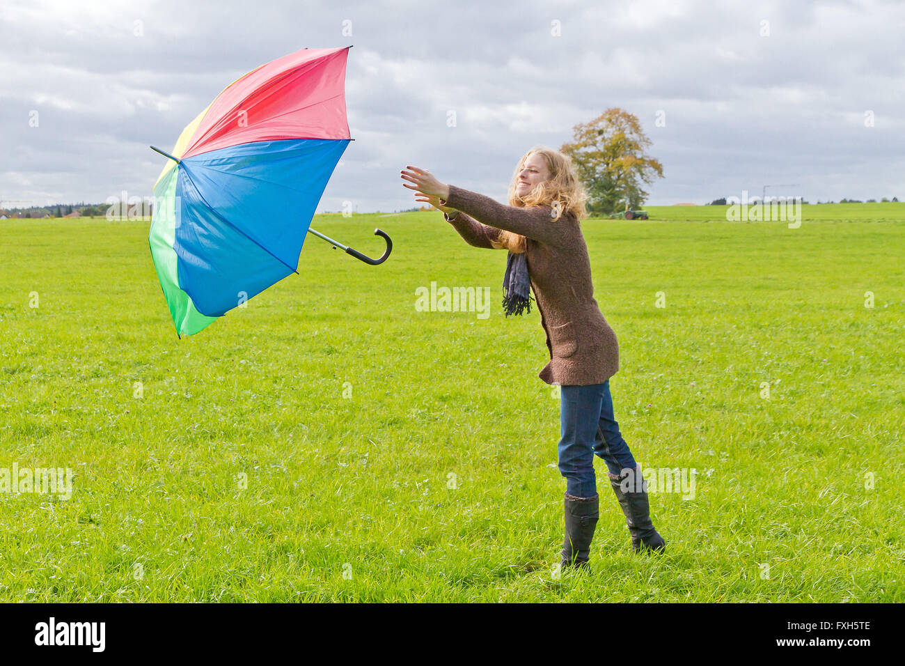 Eine junge Frau verliert ihren Schirm im wind Stockfoto