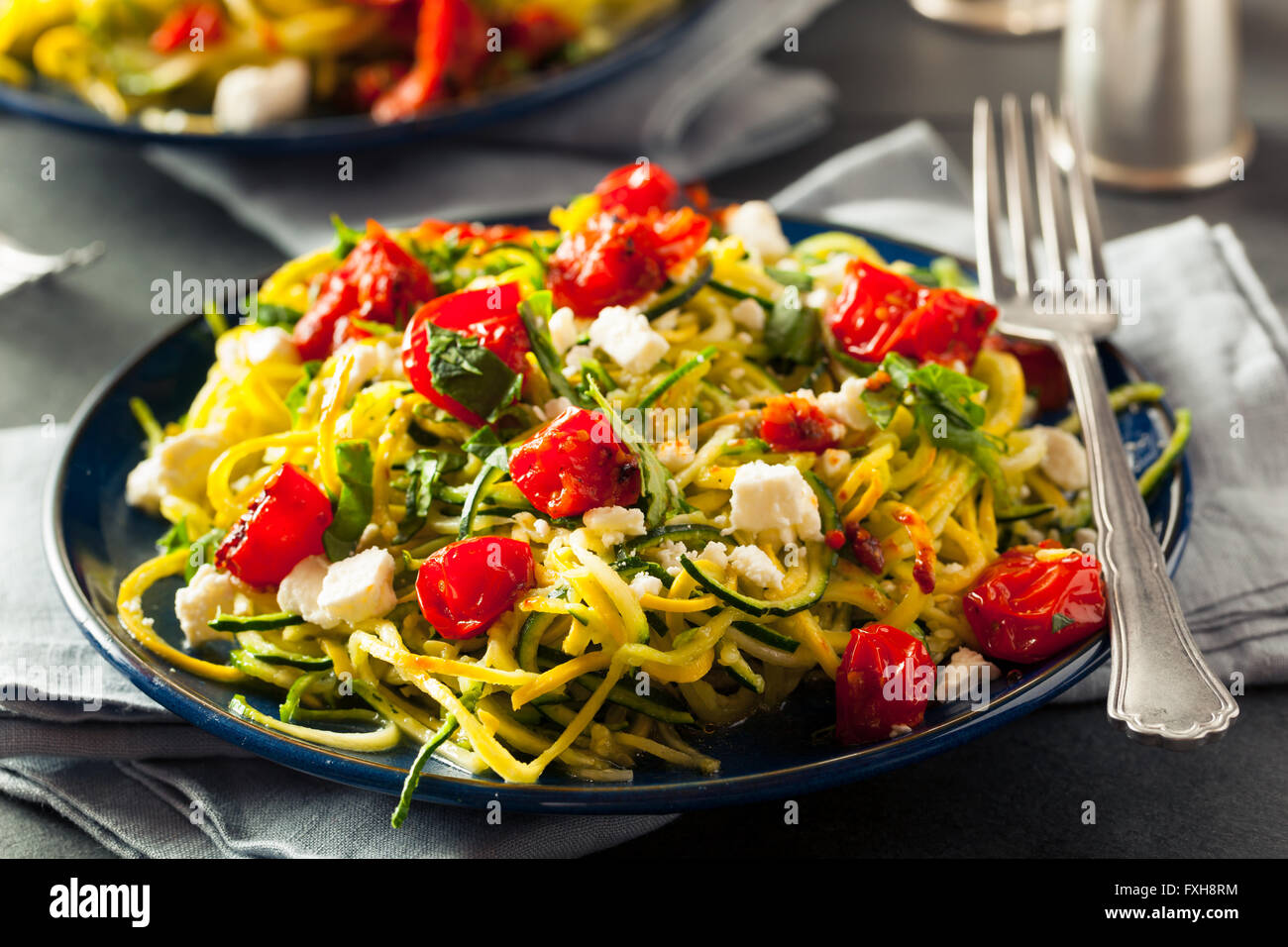 Hausgemachte Zucchini Nudeln Zoodles Pasta mit Tomaten und Feta Stockfoto