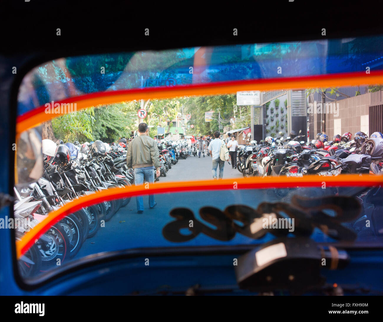 Viele Motorräder parken in einer Seitenstraße von Jakarta, wie aus einem Bemo gesehen. Stockfoto