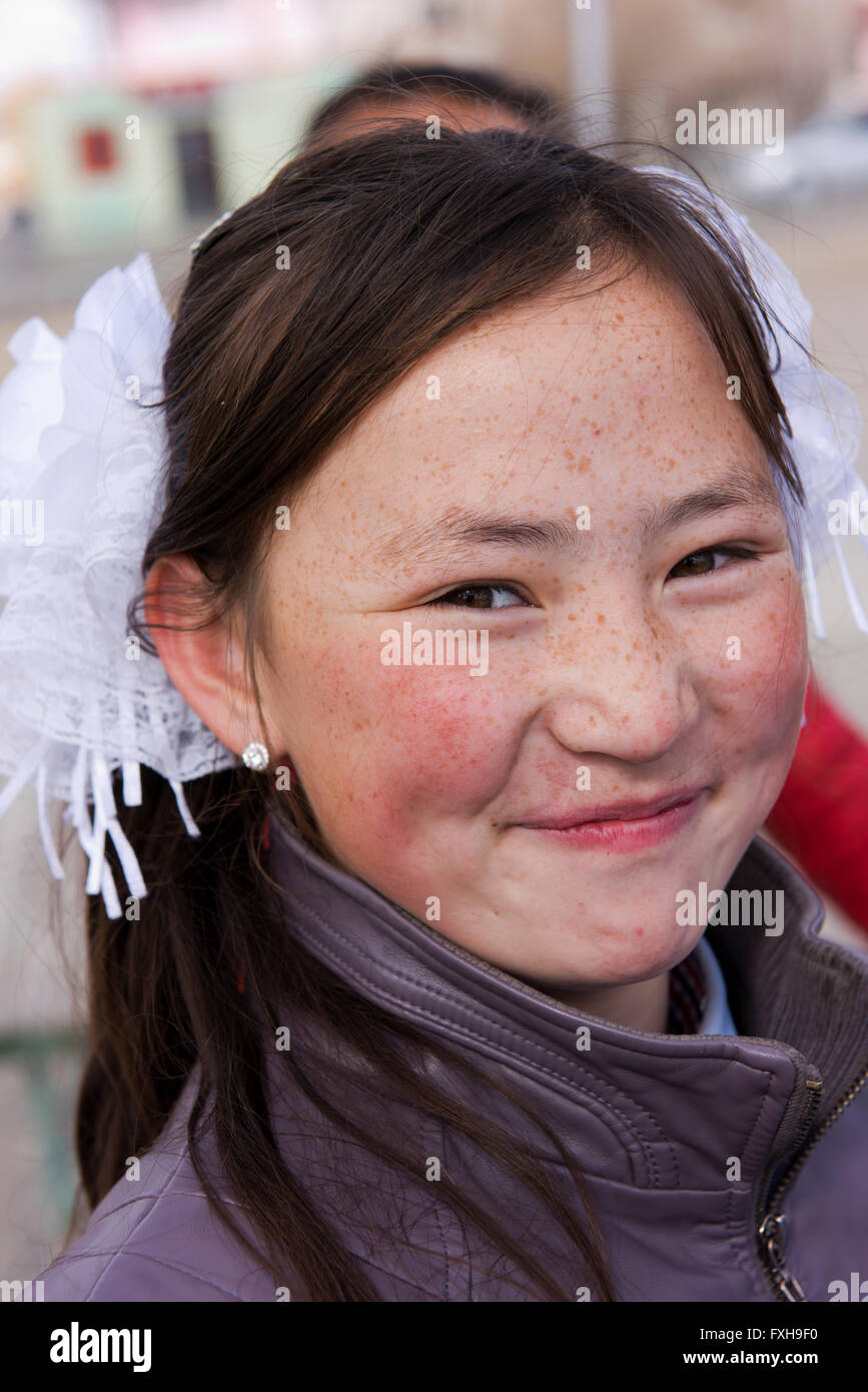 Mongolische Mädchen mit heller Haut und Sommersprossen posiert bereitwillig in Ölgii. Stockfoto