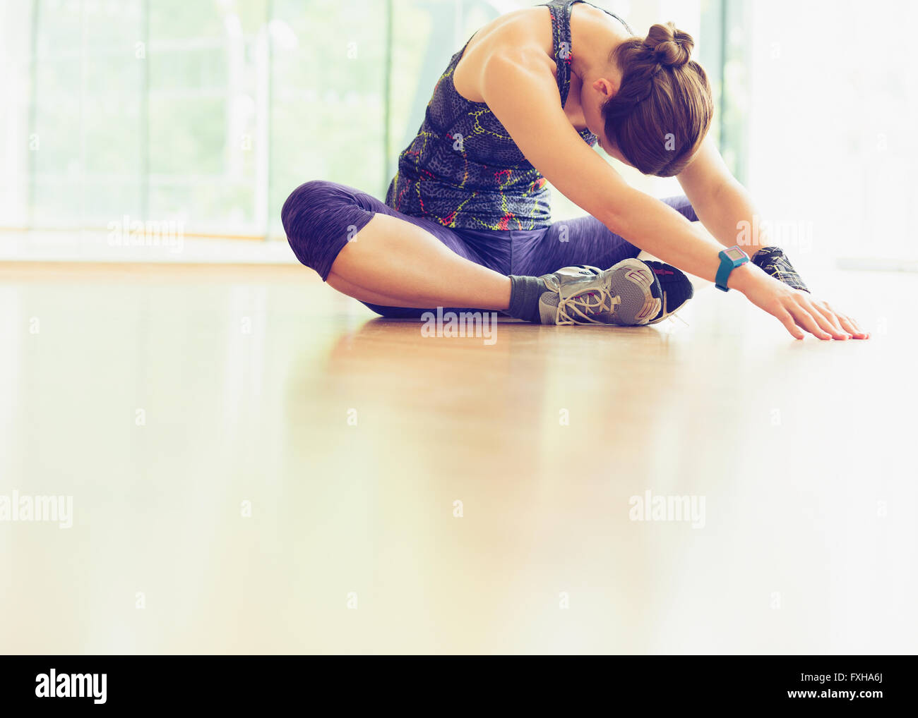 Frau, die Dehnung auf Studioboden gym Stockfoto