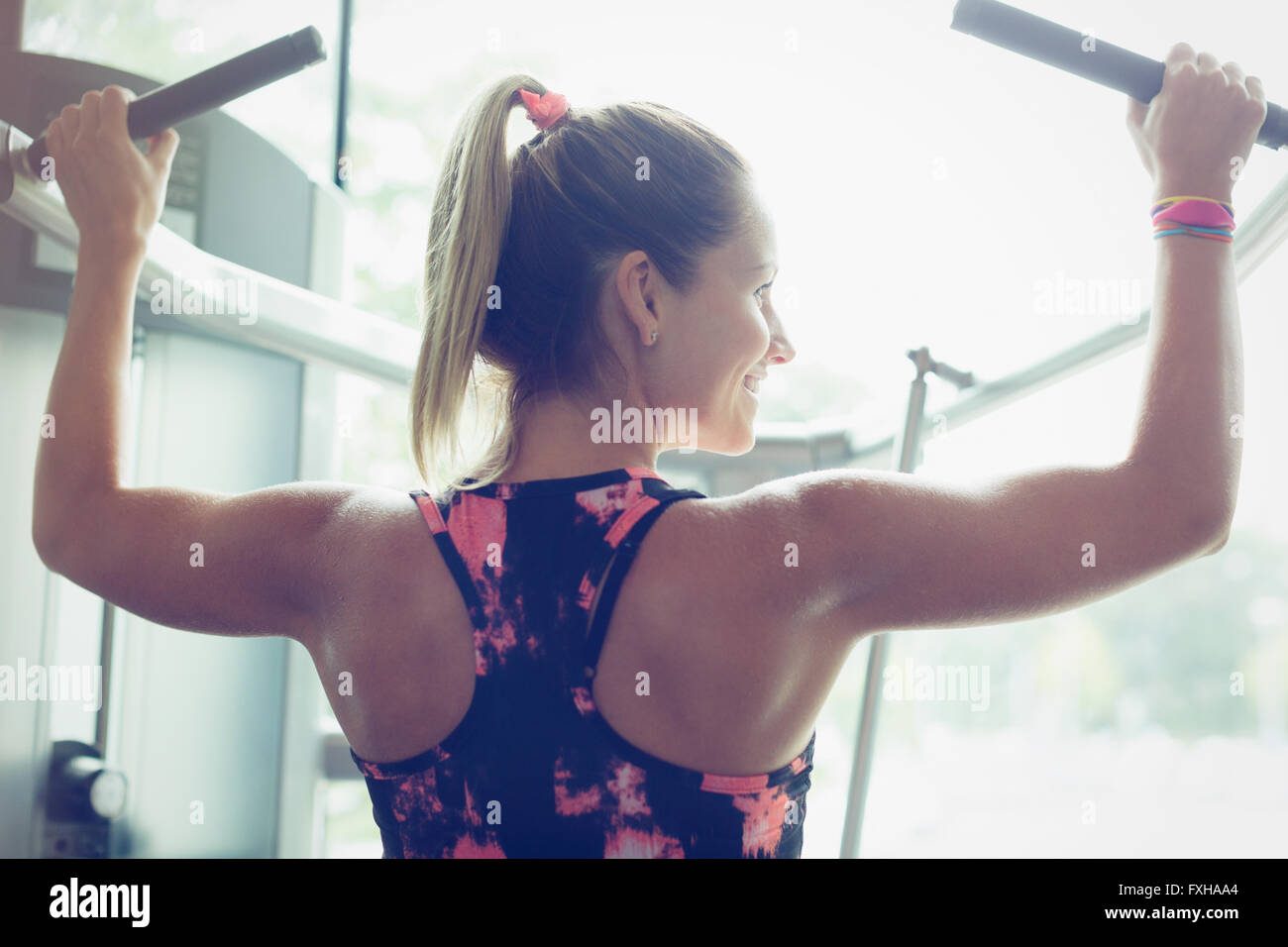 Fit Woman Lat Pulldowns an Geräten im Fitnessstudio zu tun Stockfoto