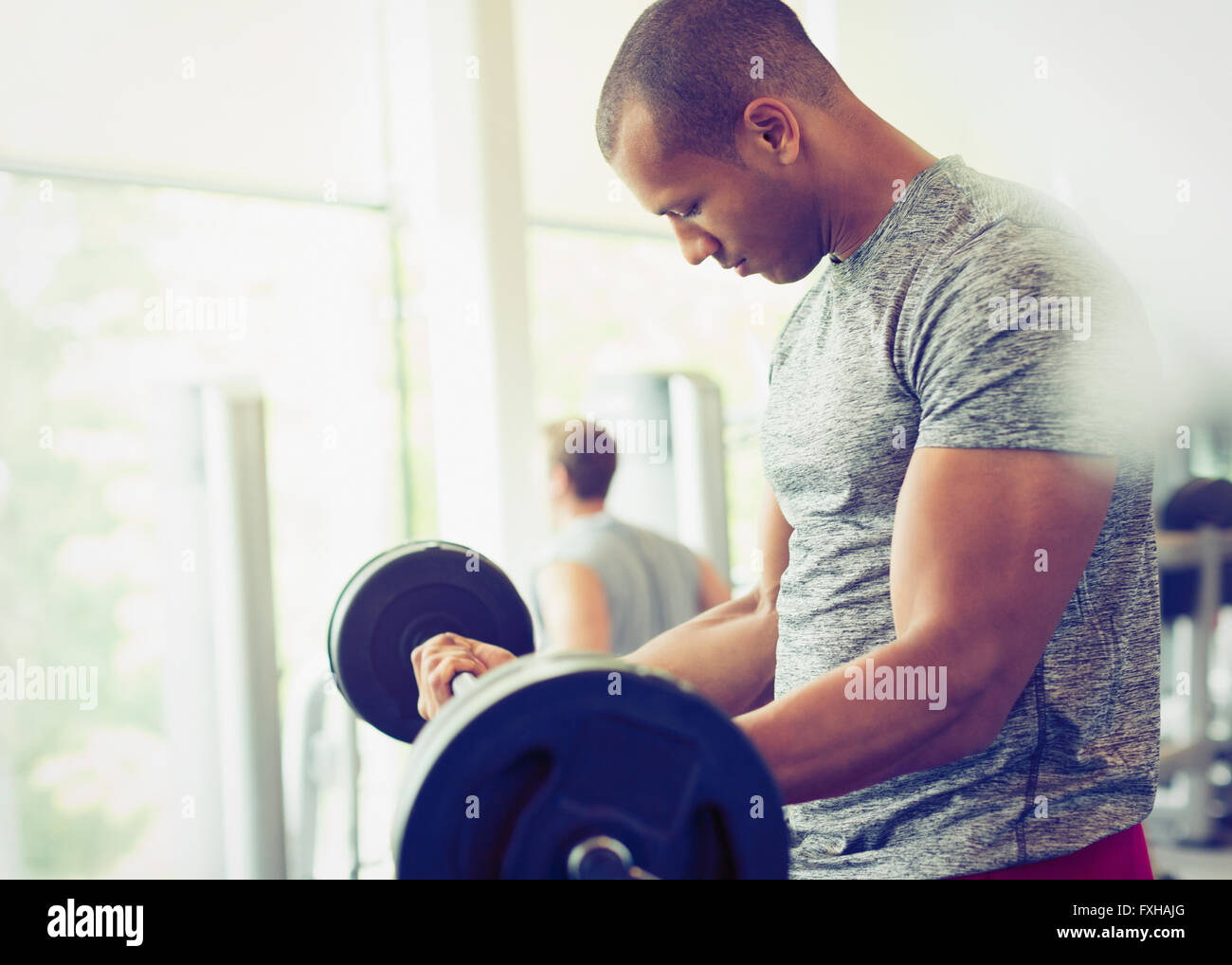 Konzentriert Mann tut Langhantel, die im Gym Bizeps curls Stockfoto