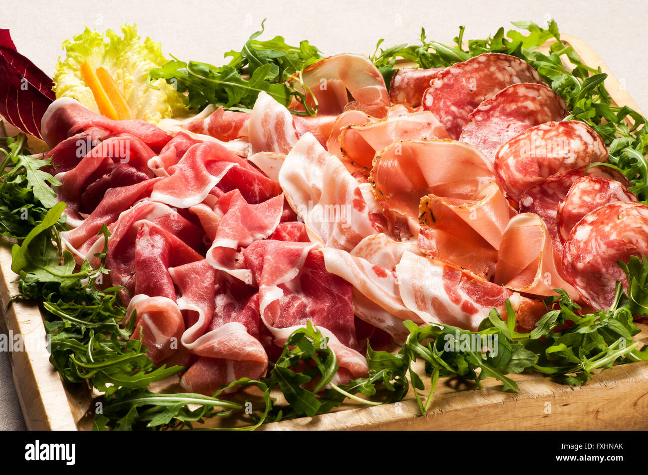 Nahaufnahme von verschiedenen Wurstwaren Fleisch Aufschnitt in Box mit Greens auf allen vier Seiten umgeben Stockfoto