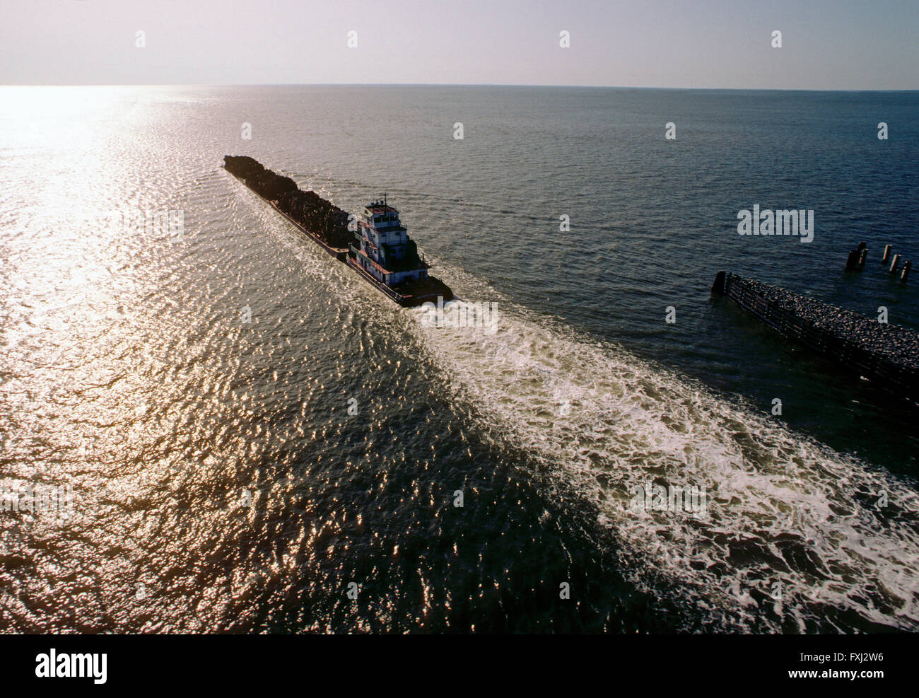 Schlepper, Lastkähne geladen mit Protokollen schieben; Houston Ship Channel; Texas; USA Stockfoto