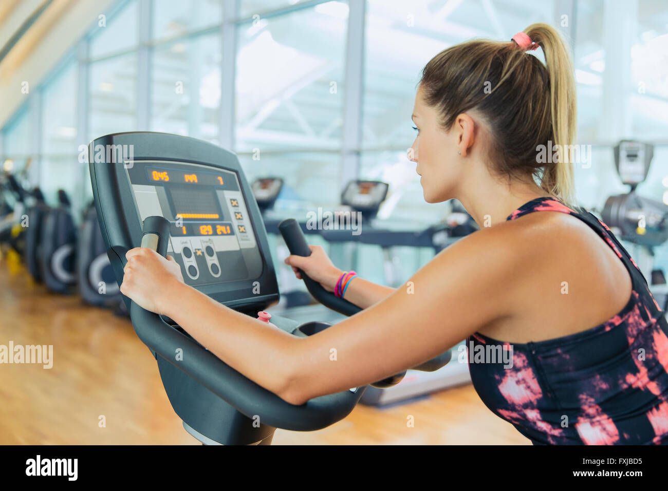 Frau Reiten Heimtrainer in Turnhalle Stockfoto