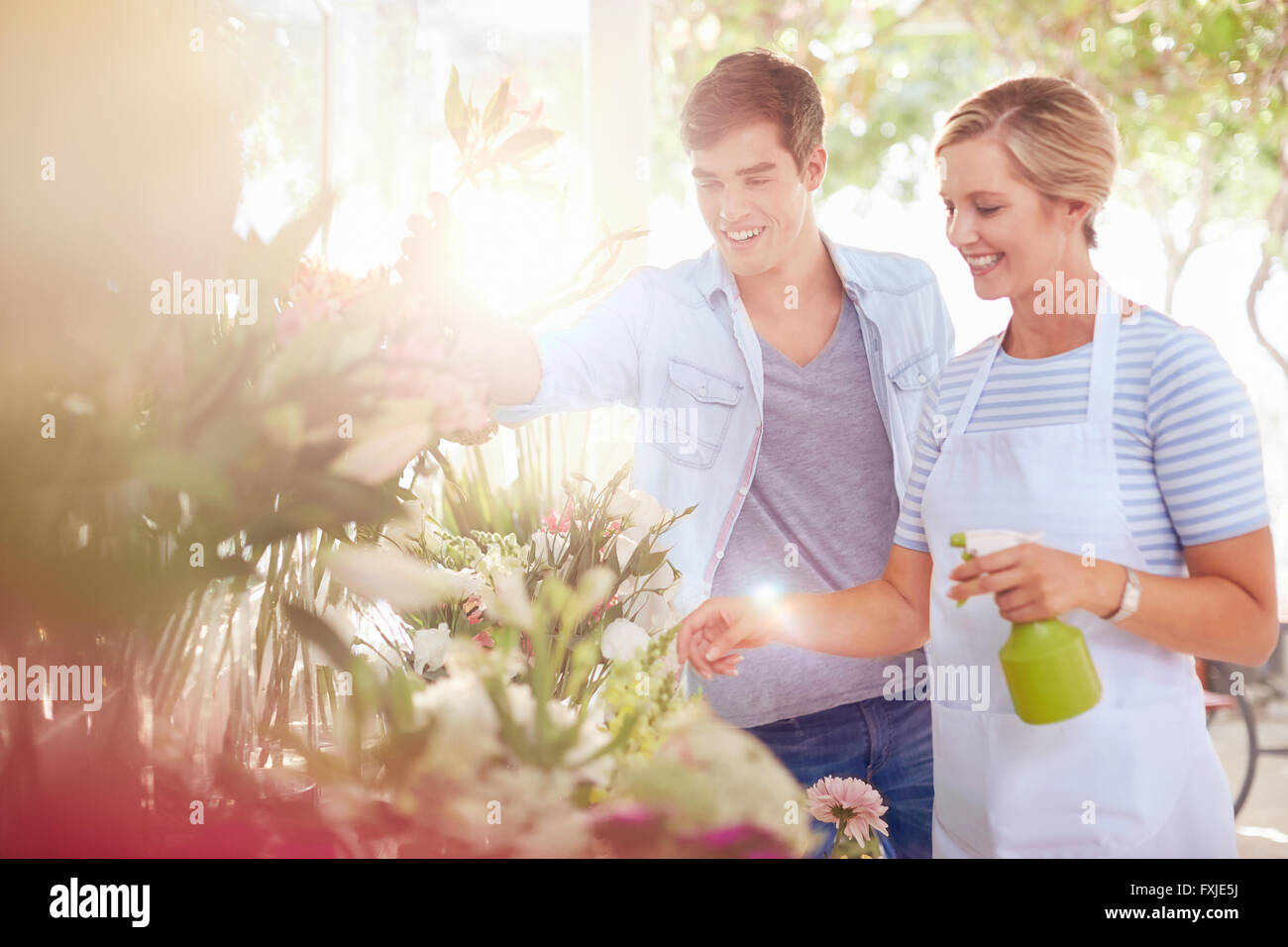 Besprühen Blumen mit Wasserflasche im Blumenladen Blumengeschäft Stockfoto