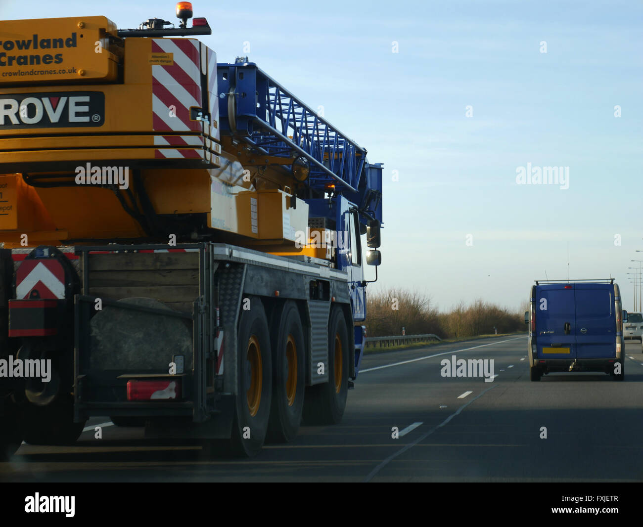 Mobiler Kran langsam voran auf der Autobahn auf dem Weg zur Arbeit Stockfoto