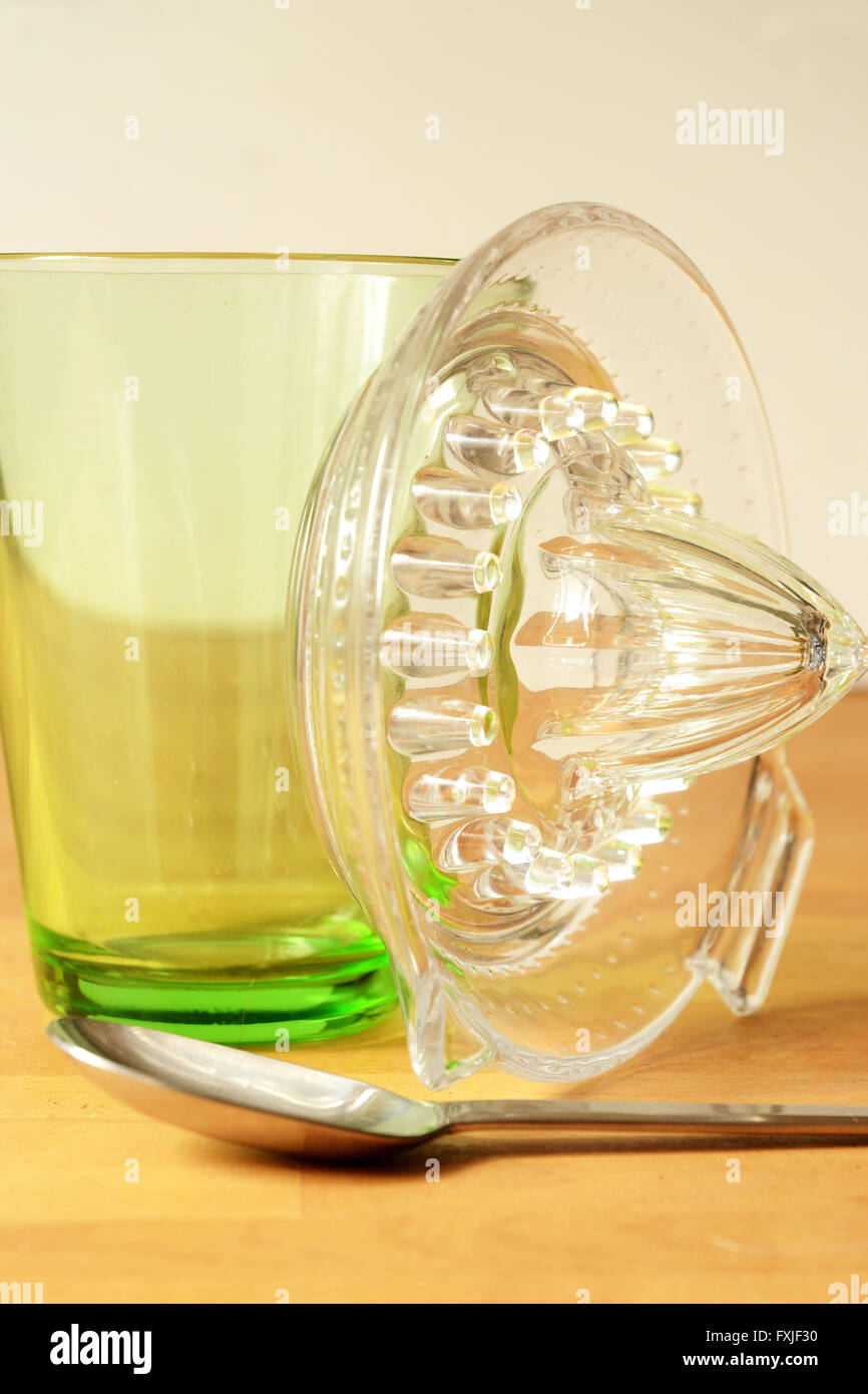 grünes Glas Becher und Löffel sitzen am Tisch mit Glas Entsafter stützte sich auf der Seite des Glases Stockfoto