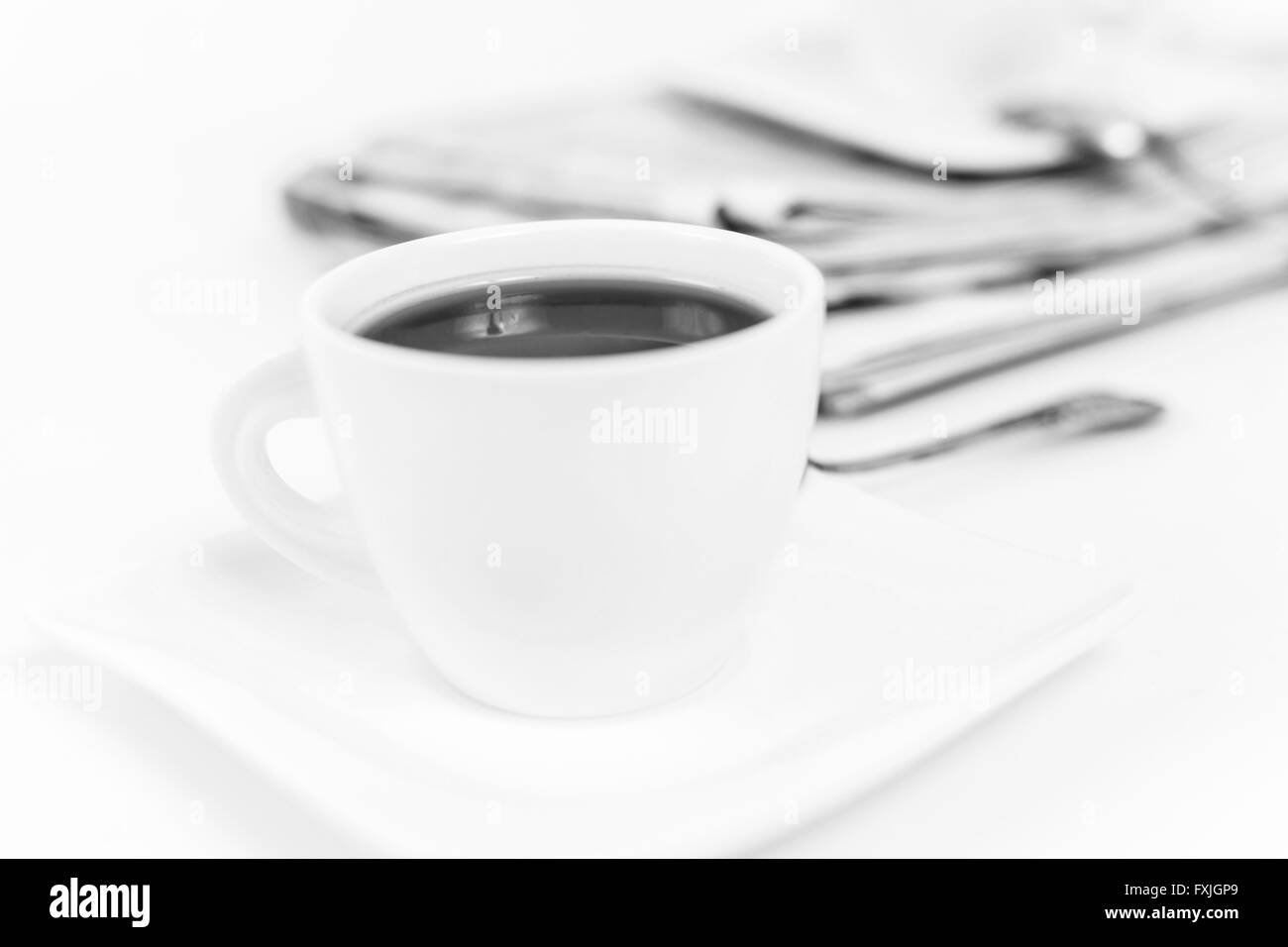 Zeitung und weißen Tasse Kaffee auf weißem Hintergrund Stockfoto