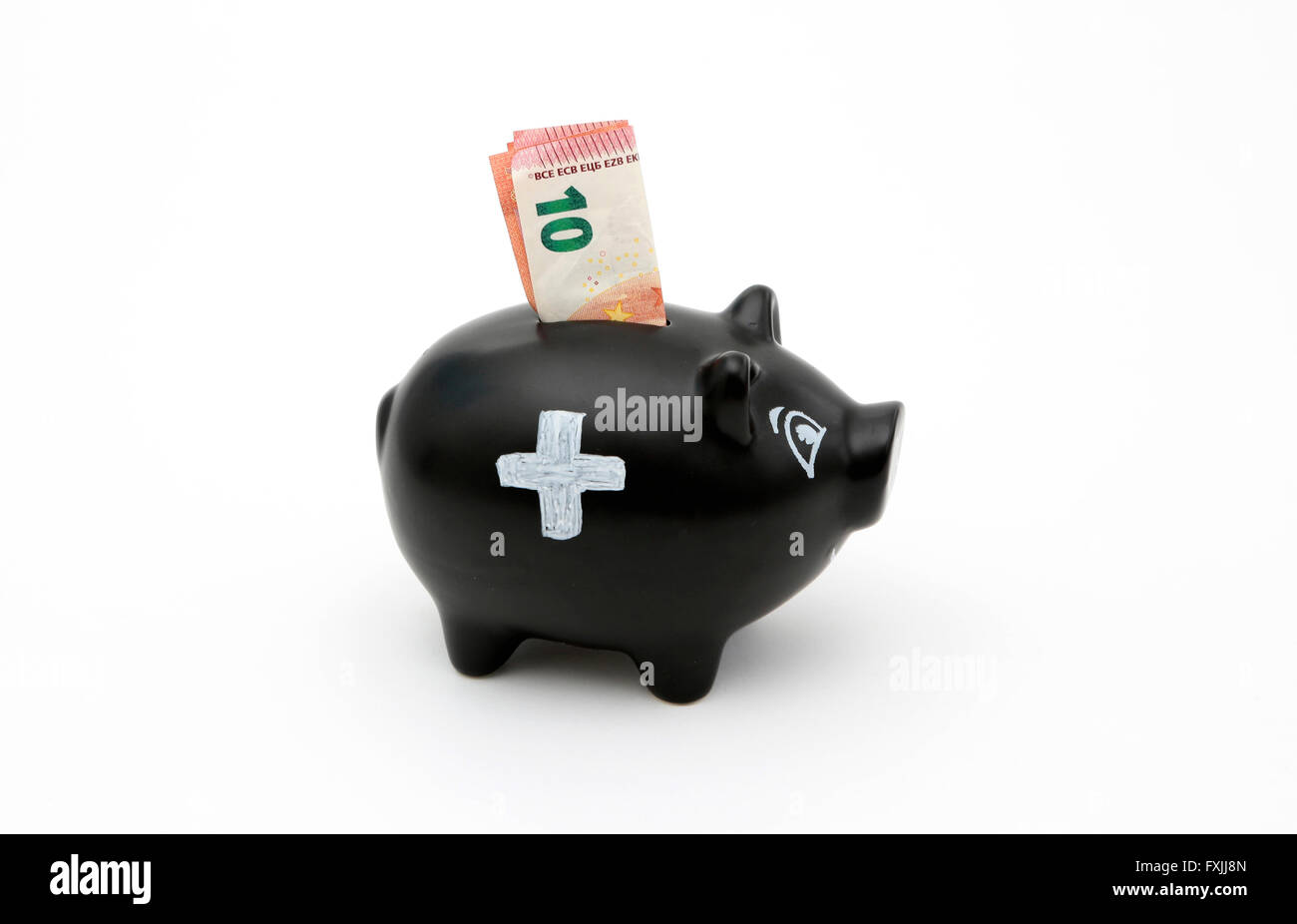Ein Sparschwein mit einem weißen Kreuz und Einsparungen für die Krankenversicherung Stockfoto