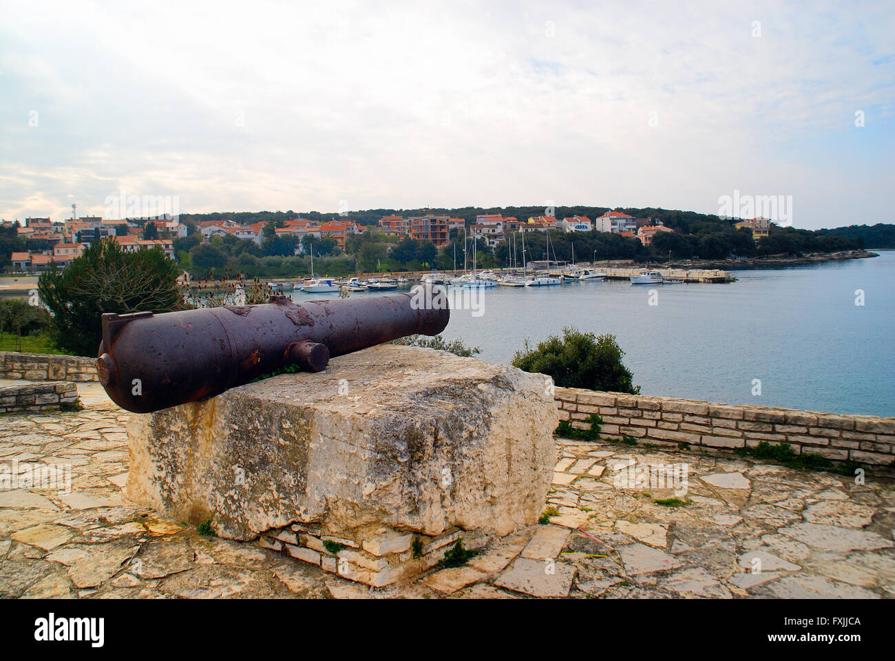 Pula, Istrien, Kroatien. Blick auf Marina Veruda von Pjescana Uvala. Im Vordergrund eine Kanone des Habsburger-Reiches. Stockfoto