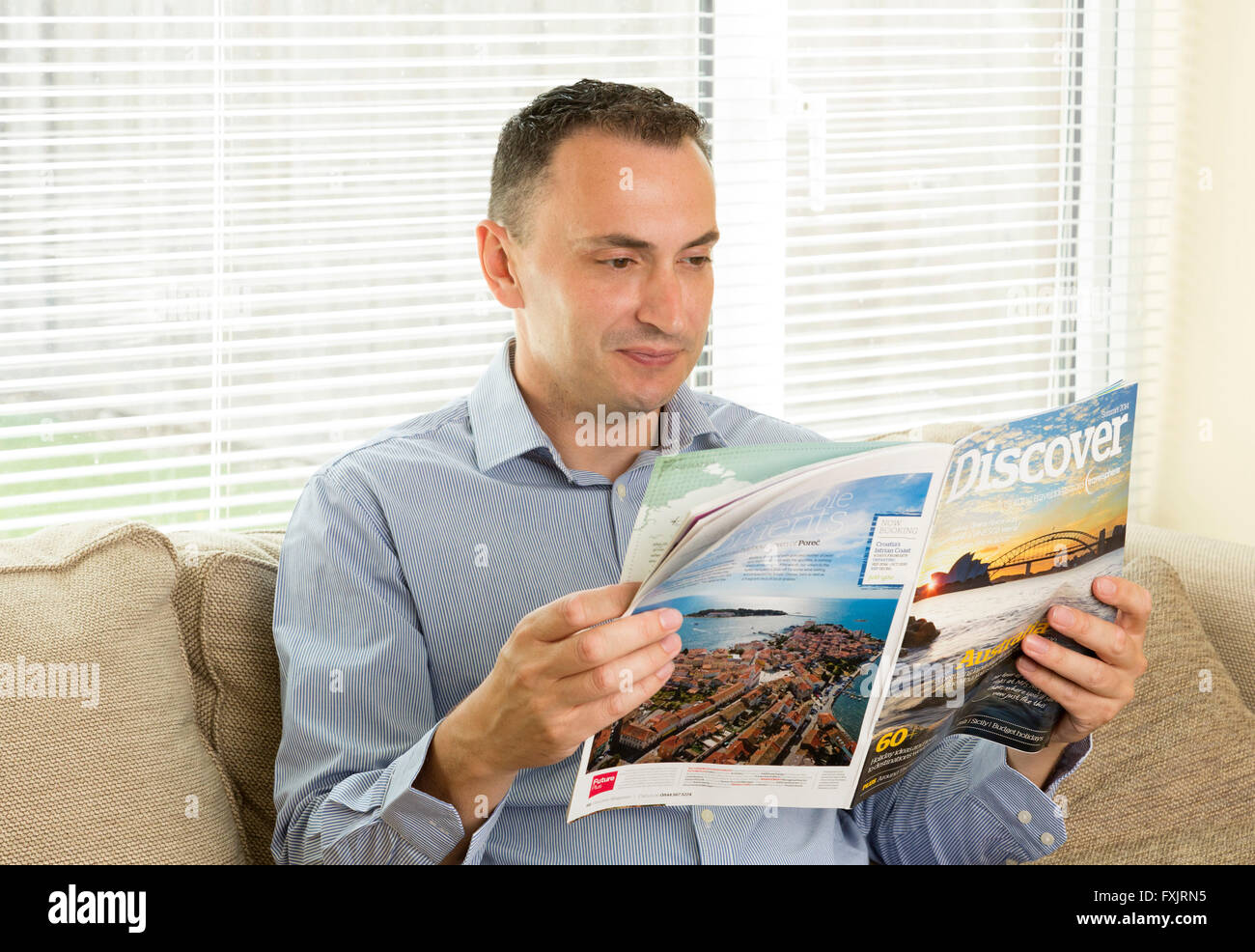 Mann liest ein Reisemagazin Reiseführer Stockfoto