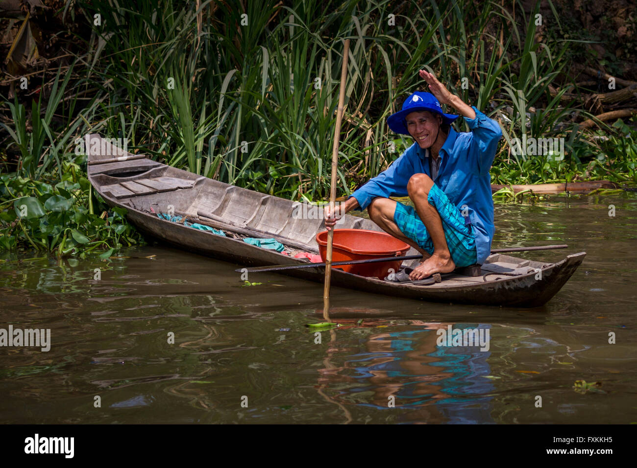 Freundliche Person Winkend aus einem kleinen Boot - vietnamesische Fischer, Chau Doc, Mekong Delta, Vietnam Stockfoto