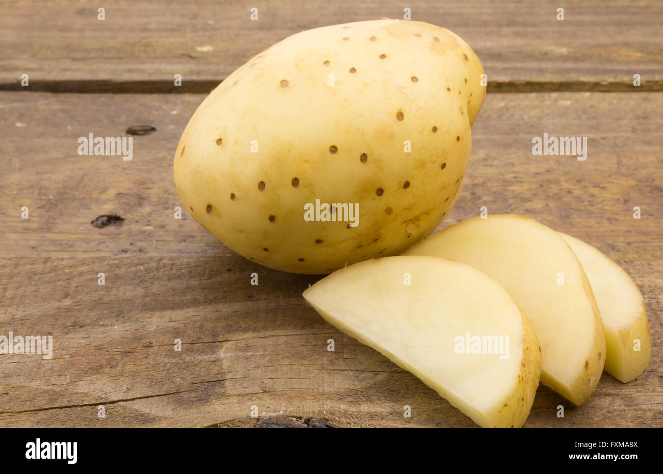 Nahaufnahme Foto der ganzen frischen Kartoffel-Scheiben auf Holztisch Stockfoto
