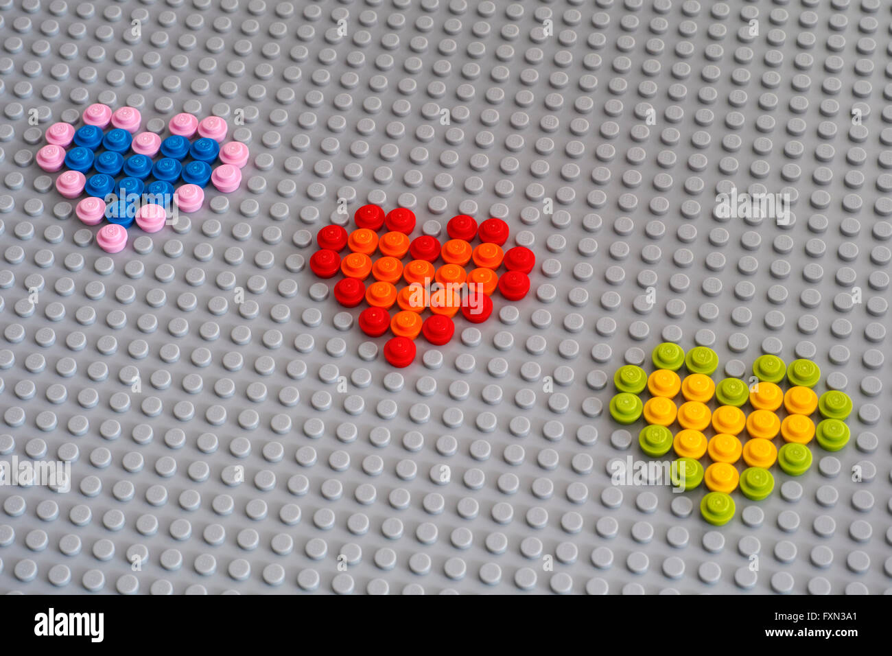 Tambow, Russische Föderation - 24. Januar 2016 drei Lego Herzen aus runden Steinen 1 x 1 auf Lego graue Grundplatte. Studio gedreht. Stockfoto