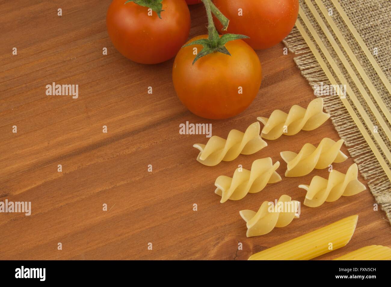 Dekoration von Teigwaren. Zubereitung von hausgemachten Speisen. Verschiedene Arten von Nudeln auf dem hölzernen Hintergrund. Erstellen des Menüs. Stockfoto