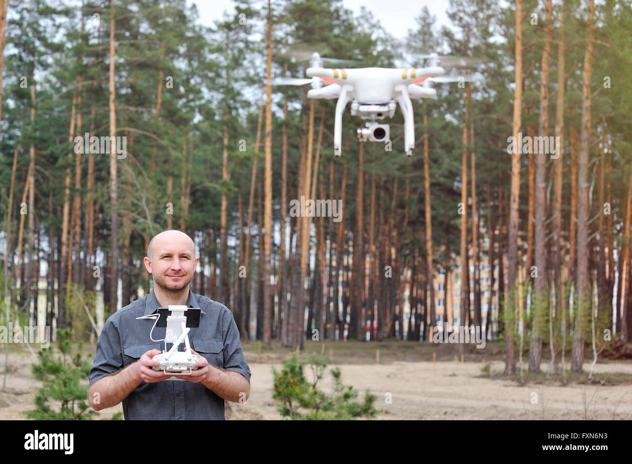 Mann mit seinem Outdoor-Drohne mit Wald-Hintergrund Stockfoto