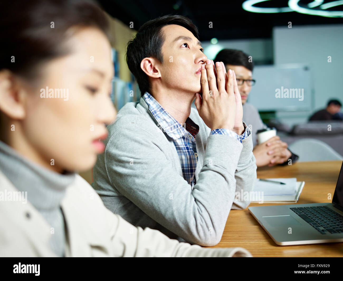 junge asiatische Unternehmer denken während der Sitzung Stockfoto