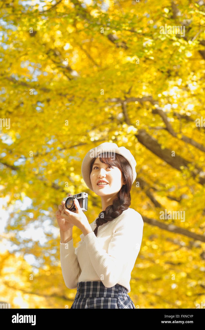Junge Japanerin mit Vintage-Kamera in einem Stadtpark Stockfoto Junge Japanerin mit Vintage-Kamera in einem Stadtpark Stockfoto