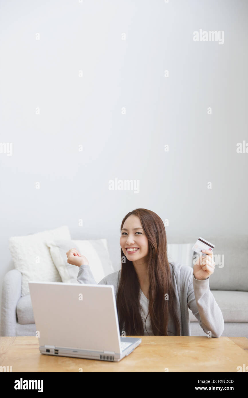 Junge attraktive Japanerin machen Online-shopping zu Hause Stockfoto