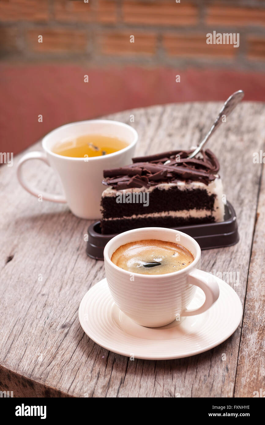 Schokoladenkuchen, heißen Tee und Espresso auf Holztisch Stockfoto