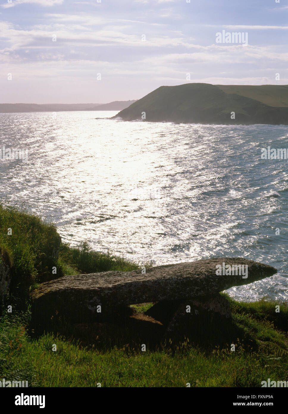 Aussehende NW über Manorbier Bucht, Pembrokeshire, auf der Erde Fast Schlussstein des Königs Quoit neolithische Grabkammer von 2 Steinen auf Edge unterstützt. Stockfoto