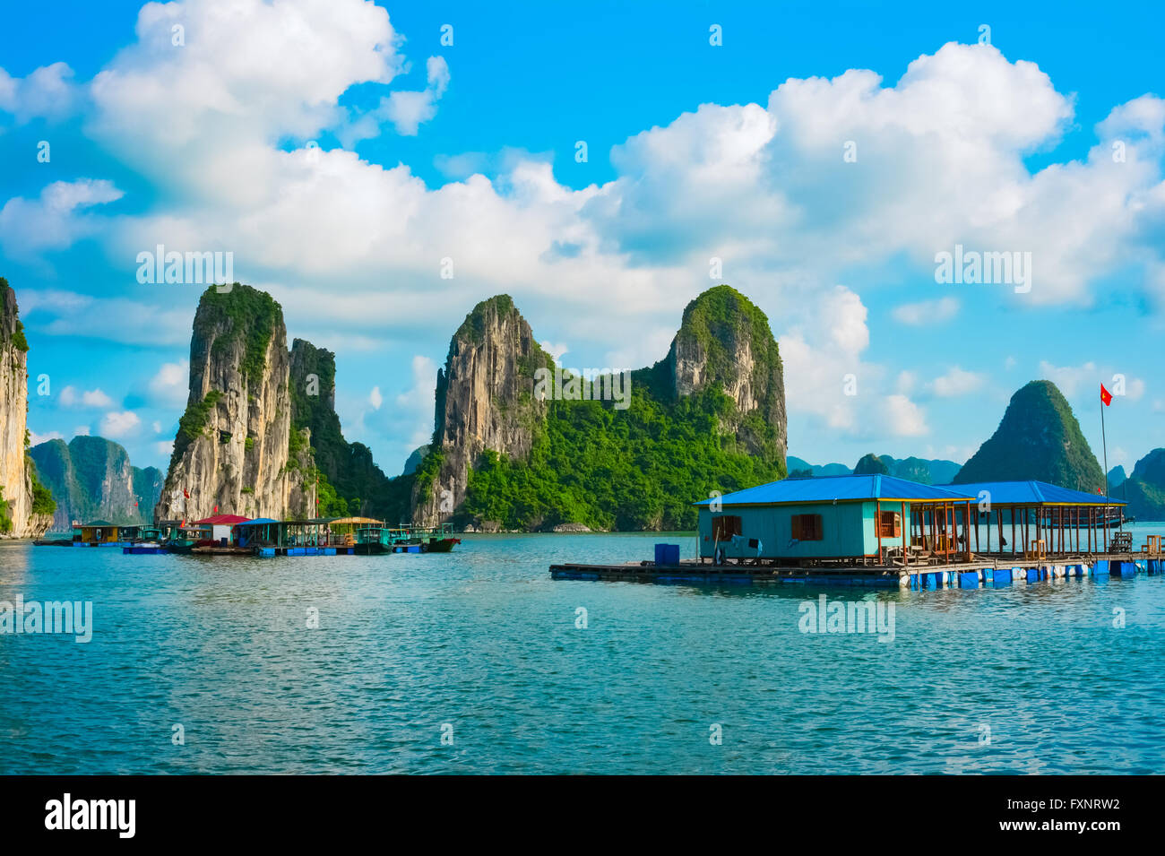 Schwimmende Dorf in der Nähe von Felsinseln in Halong Bucht, Vietnam, Südostasien. UNESCO-Weltkulturerbe. Stockfoto