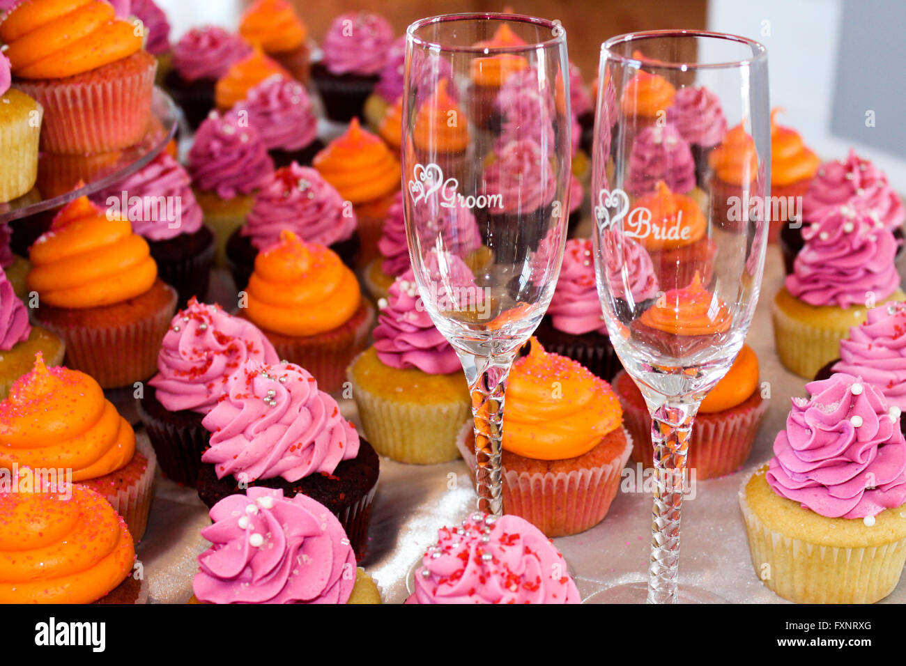 Hochzeit Cupcakes und Braut und Bräutigam Champagner Flöten Stockfoto