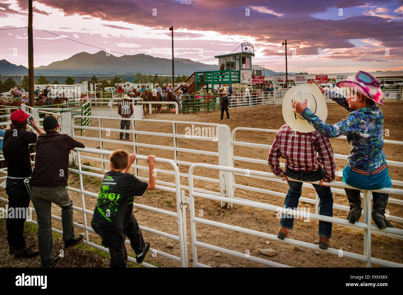 Junge & Mädchen gehockt Corral Zaun beobachten das Chaffee County Rodeo; Colorado; USA Stockfoto