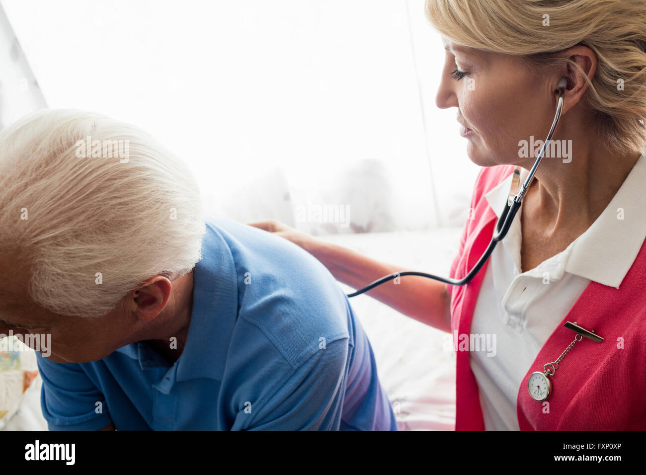 Krankenschwester mit Stethoskop, kümmern uns um einen älteren Mann Stockfoto