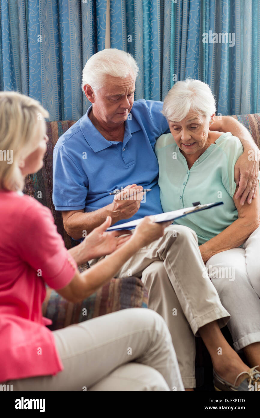 Krankenschwester macht einen Vertrag mit ein älteres paar Stockfoto